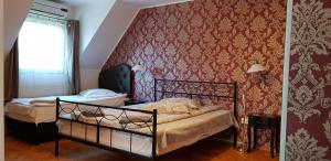 1 dormitorio con 2 camas y pared roja en Pension Casa Leone en Timisoara