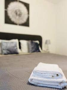 una pila de toallas sentadas encima de una cama en AV Apartment, en Turda