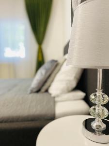 una lámpara en una mesa junto a un sofá en AV Apartment, en Turda