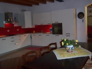 uma cozinha com uma mesa com um vaso de flores em B&B Corte Barbieri em Dolcè