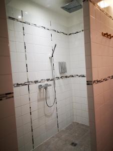 y baño con ducha de azulejos blancos. en la halte des trois rivieres en Plichancourt