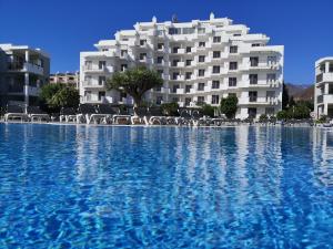 een groot zwembad voor een gebouw bij HG Tenerife Sur in Los Cristianos