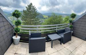 einen Balkon mit 2 Stühlen und einem Tisch in der Unterkunft Auszeit-Winterberg in Winterberg