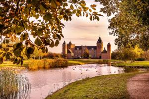 un castillo con un estanque delante de él en Singel 9 en Domburg