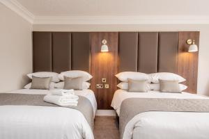 a hotel room with two beds with white sheets at Bredbury Hall Hotel in Stockport