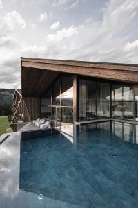 una casa con una piscina di fronte di AEON Hotel - adults only Bed & Breakfast a Soprabolzano