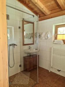 a bathroom with a shower and a sink and a mirror at Das Resort Brixen in Brixen im Thale