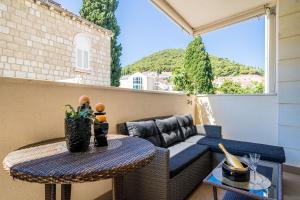 um pequeno pátio com um sofá e uma mesa em Apartment Iris em Dubrovnik