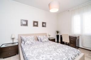 a white bedroom with a bed and a desk at Apartment Iris in Dubrovnik