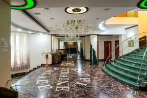 a lobby with a staircase and a chandelier at Hotel Palace Ukraine in Mykolaiv