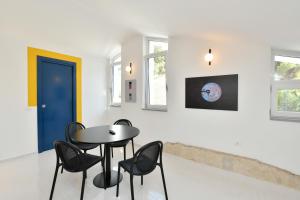 ein Esszimmer mit einem Tisch, Stühlen und einer blauen Tür in der Unterkunft La Rocchetta in Santa Maria di Castellabate