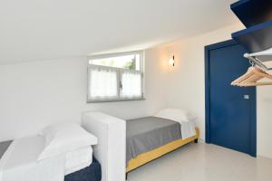 ein Schlafzimmer mit einem Bett und einer blauen Tür in der Unterkunft La Rocchetta in Santa Maria di Castellabate