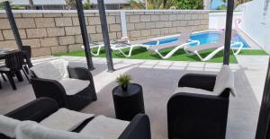 un patio con sillas y una piscina en Villa Orquídea, en Callao Salvaje