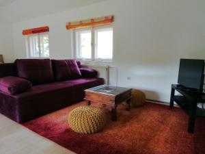 Galambok的住宿－Waldhaus Pat，客厅配有紫色沙发和茶几