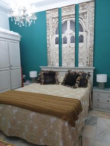 カディスにあるAcogedor Apartamentoのベッドルーム1室(青い壁のベッド1台、シャンデリア付)