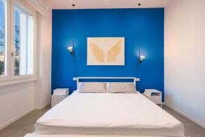 een slaapkamer met een blauwe muur en een bed bij Suite nel Largo in Cagliari