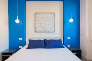 1 dormitorio con paredes azules y 1 cama con almohadas azules en Suite nel Largo, en Cagliari