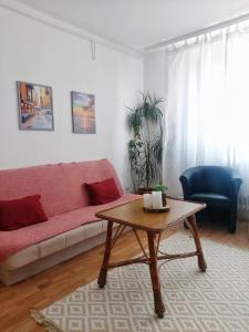 a living room with a red couch and a coffee table at Sunshine apartment in Pančevo