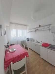 a kitchen with a table with a red polka dot table cloth at Sunshine apartment in Pančevo