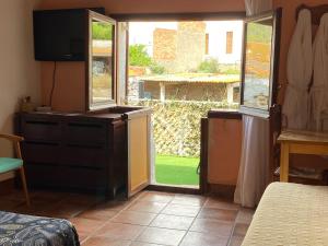 1 dormitorio con una puerta que conduce a un patio en La Olivera APARTHotel Rural Suites bañera hidro o Jacuzzi privados, en Albinyana