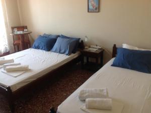 two beds in a room with blue pillows and towels at FILIPPOS-Spectacular area,,,-sea- view- apartments with parking-49m2-just call for price,vacancy etc,,-next to Vallis hotel,, 15meters from seaside!!! in Agria