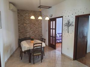a dining room with a table and chairs and a brick wall at Apartment 2 in Podstrana