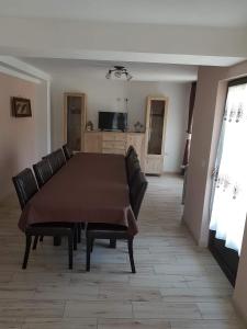 un soggiorno con tavolo e sedie in pelle di Casa Alma a Borşa