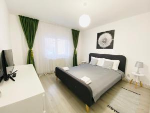 a bedroom with a bed and a desk and a television at AV Apartment in Turda