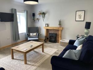 a living room with a couch and a coffee table at Derrie Farm Cottage in Newton Stewart
