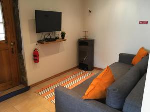 a living room with a couch and a flat screen tv at Palheiro do Vale do Paiva in Cabril