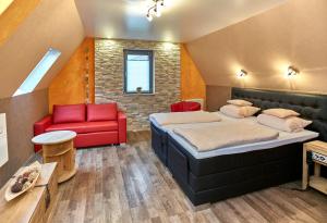 een slaapkamer met 2 bedden en een rode bank bij Hotel Naheschlößchen in Bad Münster am Stein-Ebernburg