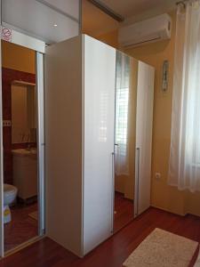 a large white cabinet in a room with a bathroom at Apartment King in Opatija