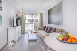 a living room with a couch and a table with a bowl of fruit at Aldara Home by Best Holidays Fuerteventura in Corralejo