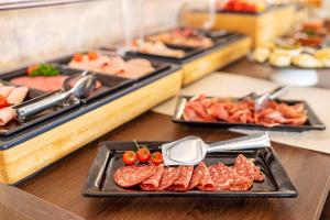 a buffet with different types of meats and other foods at Hotel Paradise Residencial in Cala Ratjada