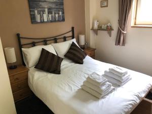 a bedroom with a white bed with towels on it at Le Grand Camelia in Saint-Martin-dʼAubigny