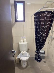 a bathroom with a toilet and a shower curtain at Amaryllis Hotel in Rhodes Town