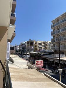 un panneau de supermarché sur une rue de la ville avec des bâtiments dans l'établissement Amaryllis Hotel, à Rhodes