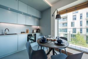 una sala da pranzo con tavolo e sedie e una cucina di Yacht Park Marina View - BillBerry Apartments a Gdynia