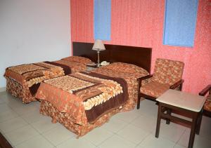 Sangam Hotel Muzaffarabad في مظفر اباد: غرفة فندقية بسريرين وكرسي