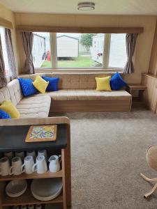 a living room with a couch and a large window at Seahawk Lodge in Whitley Bay