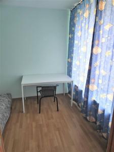 a table and a chair in a room with a curtain at Dzīvoklis ģimenei 100 metri no jūras in Jūrmala