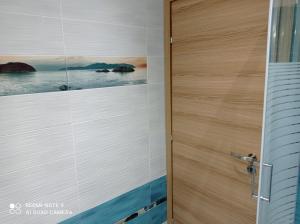 a door in a bathroom with a picture on the wall at Sunset Apartment in Epanomi