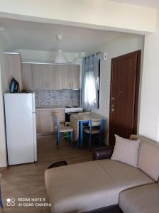 a living room with a couch and a kitchen at Sunset Apartment in Epanomi