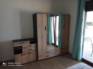 a large wooden dresser with a mirror in a room at Sunset Apartment in Epanomi
