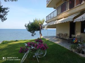 a bike parked next to a house with flowers at Sunset Apartment in Epanomi