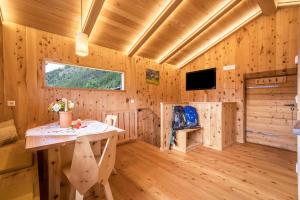 a log cabin with a table and a television at Kornkammer Lodge - Patleidhof in Naturno
