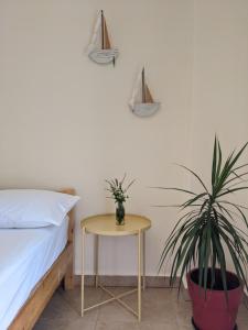 ハニア・タウンにあるEvantia's Cosy Studioのベッドルーム1室(ベッド1台、植物のあるテーブル付)