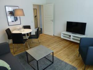 uma sala de estar com uma mesa e uma televisão de ecrã plano em Australiensvej em Copenhague