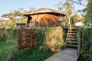 a small tree house with a wooden walkway and a sign at Tava Lago in San Bernardino
