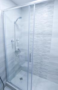 y baño con ducha y puerta de cristal. en Liliana's Apartments en Kutaisi